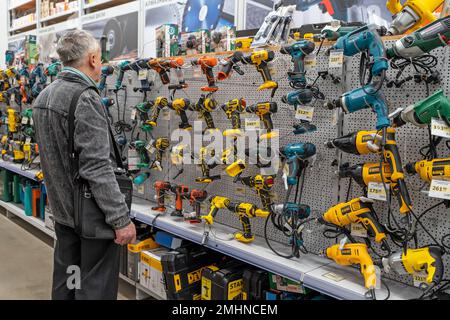 Ein Mann wählt ein Elektrowerkzeug in einem Baumarkt. Stockfoto