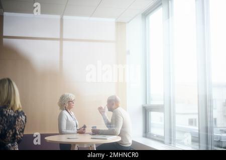 Geschäftsleute sprechen während der Kaffeepause Stockfoto