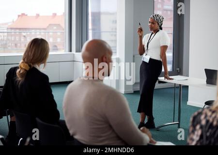 Frau, die während eines Geschäftstreffens eine Präsentation hält Stockfoto