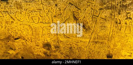 Die Royston Cave in Herfordshire, Großbritannien, verwirrt heute noch Historiker. Die Figur ganz links auf dem Bild mit den erhobenen Armen könnte König David aus dem Buch der Psalmen sein. Royston Cave in Katherine's Yard, Melbourn Street, Royston, England Stockfoto