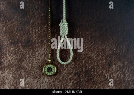 Hangmans Schlinge und klassisches Taschenuhrkonzept auf meliertem Hintergrund Stockfoto