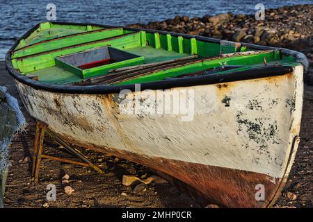 Am Strand steht ein altes, renovierungsbedürftiges Fischerboot Stockfoto