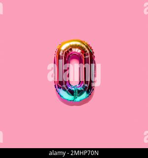 Nummer des Regenbogenfolien-Ballons, Ziffer Null. Draufsicht. Farbige Ziffer auf pinkfarbenem Hintergrund. Stockfoto