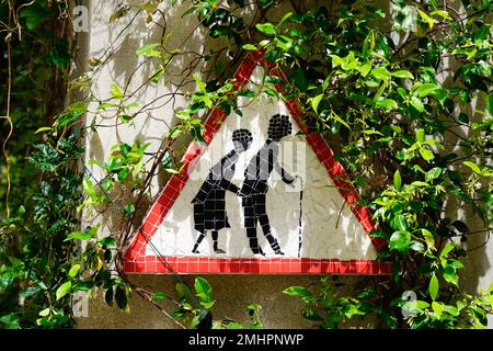 Hinweisschild für den älteren Menschen auf einem Baum in der Nähe der Strasse Stockfoto