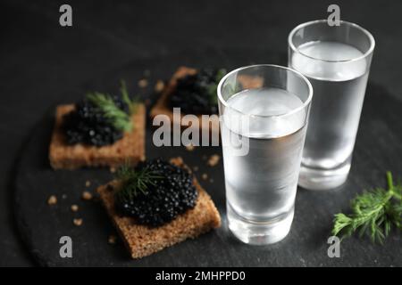 Kalter russischer Wodka und Sandwiches mit schwarzem Kaviar auf dem Tisch, Nahaufnahme Stockfoto