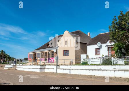 Elim, Südafrika - 21. September 2022: Eine Straßenszene mit dem Royal Cafe und einem historischen Haus in Elim, in der Provinz Westkap Stockfoto