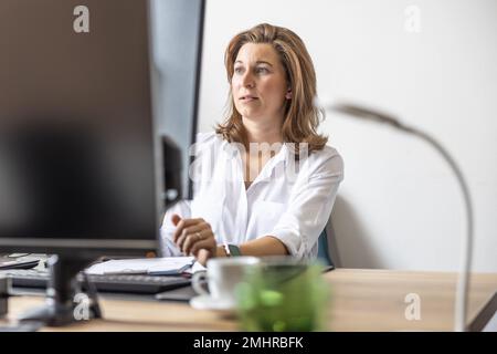 Eine Buchhalterin oder Geschäftsfrau arbeitet in ihrem Büro an einem Computer. Stockfoto