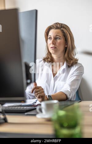 Eine Buchhalterin oder Geschäftsfrau arbeitet in ihrem Büro an einem Computer. Stockfoto