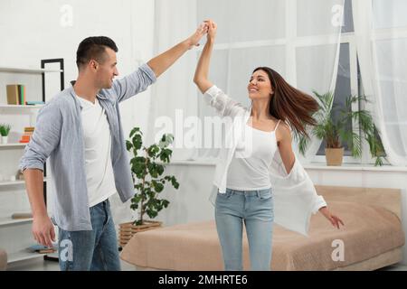 Glückliches Paar, das zu Hause im Schlafzimmer tanzt Stockfoto