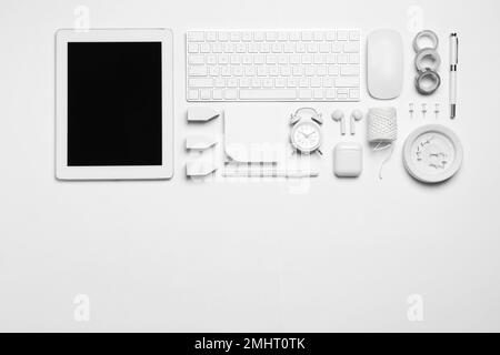 Flach liegend mit Tablet und verschiedenen Bürogegenständen auf weißem Hintergrund. Arbeitsplatz des Designers, Platz für Text Stockfoto