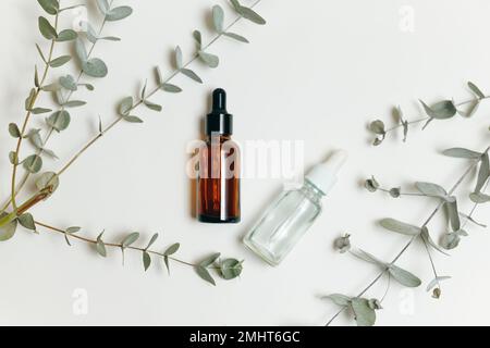 Zwei Tropfflaschen aus Kosmetikglas mit ätherischem Öl oder Serum auf weißem Hintergrund. Flach verlegt. Stockfoto