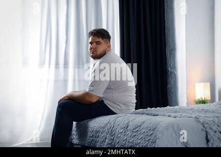 Deprimierter übergewichtiger Mann im Bett zu Hause Stockfoto