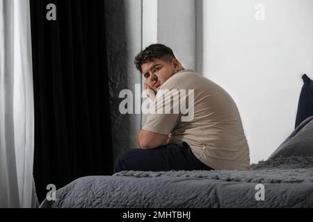 Deprimierter übergewichtiger Mann im Bett zu Hause Stockfoto