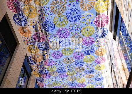 Bunte Regenschirme bunt durchsichtiger Regenbogen über der Straße Stockfoto