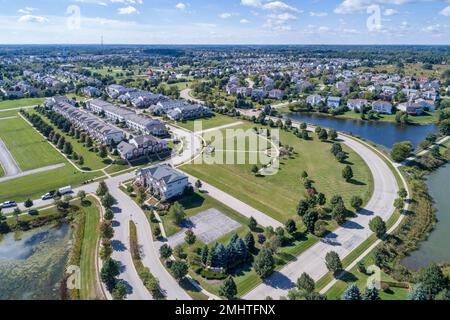 Luftaufnahme von ein Stadthaus und Gehäuse Gemeinschaft mit Teich in einem Vorort. Stockfoto