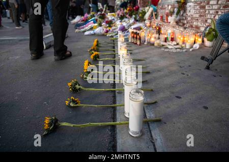 Monterey Park, Usa. 25. Januar 2023. Eine Reihe von elf Kerzen und Sonnenblumen wird zu Ehren der 11 Opfer platziert, die während der Monterey Park Mass Schießerei ihr Leben verloren haben. Die Mitglieder der Gemeinschaft versammeln sich zum vierten Mal, als Vigil für die Opfer der Massenschießerei im Monterey Park festgehalten wurde, bei der Vizepräsidentin Kamala Harris einen kurzen Besuch abstattete, um einen Kranz zu legen und mit den Opfern des Massakers zu plaudern, das am 21. Januar 2023 in Monterey Park stattfand, Calif im Star Dance Studio. Kredit: SOPA Images Limited/Alamy Live News Stockfoto