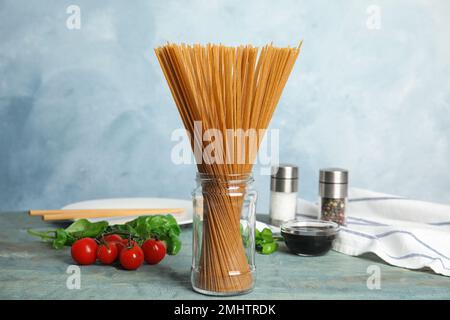 Ungekochte Buchweizen-Nudeln und frische Zutaten auf blauem Holztisch Stockfoto