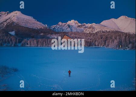 Mensch und Winter Natur: Die Ruhe von Strbske Pleso in der Hohen Tatra an einem Winterabend, bevor die Sonne untergeht Stockfoto
