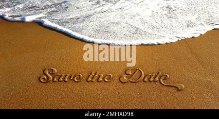 Speichern Sie das Datum Textzeichen geprägte Beschriftung am Sandstrand mit weißer Meereswelle. Foto Stockfoto