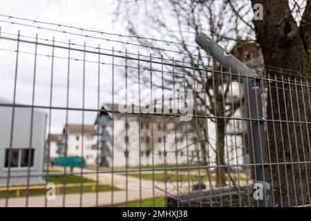 Freiburg, Deutschland. 27. Januar 2023. Ein teilweise mit Stacheldraht versehener Zaun umgibt das Gelände der ursprünglichen staatlichen Aufnahmeeinrichtung (LEA) in Freiburg. Nach Unruhen in der Freiburger Flüchtlingsanlage werden Lösungen gesucht. Die Staatsanwaltschaft, die Polizei und der regionalrat sind beteiligt, und zu diesem Zweck wurde auch eine Sitzung geplant. Seit dem Wochenende gab es mehrere Unruhen in der ursprünglichen Auffangeinrichtung. Kredit: Philipp von Ditfurth/dpa/Alamy Live News Stockfoto