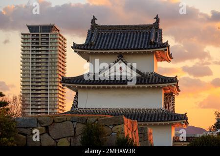 Sonnenuntergang über dem Wachturm im japanischen Schloss und einem modernen Hochhaus Stockfoto