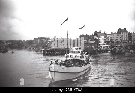 1950, historisch, voller Passagiere, das Vergnügungsboot „Boys Own“ verlässt den Hafen in Bridlington, East Yorkshire, England, Großbritannien. „Boys Own“ wurde 1938 erbaut und war eines von fünf Ausflugsschiffen, die in dieser Zeit in Bridlington eingesetzt wurden, bekannt als „die Belles der Nordsee“. Stockfoto