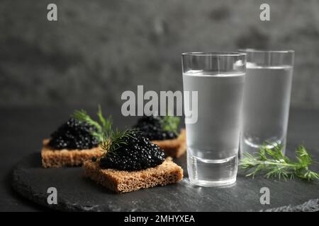 Kalter russischer Wodka und Sandwiches mit schwarzem Kaviar auf dem Tisch, Nahaufnahme Stockfoto