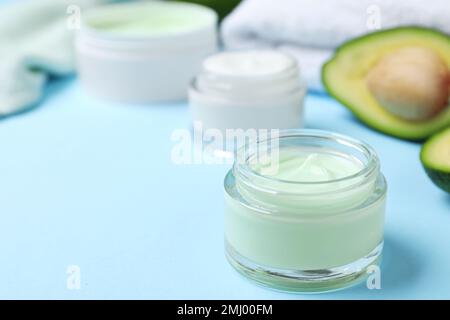 Offenes Glas Creme auf blauem Hintergrund. Platz für Text Stockfoto