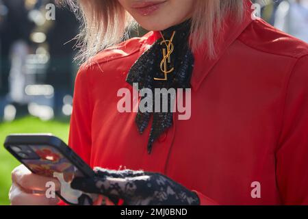 MAILAND, ITALIEN - 14. JANUAR 2023: Frau mit schwarzem Paillettenband und goldenem Yves Saint Laurent-Logo vor der Modenschau von Emporio Armani, Milan Fashion Stockfoto