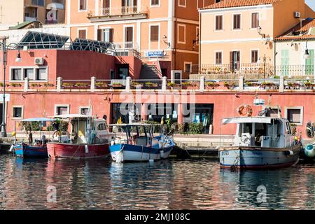Festgemachte Fischerboote und Gebäude am Wasser im Hafen von La Maddalena auf der Insel La Maddalena, Sardinien, Italien. Stockfoto