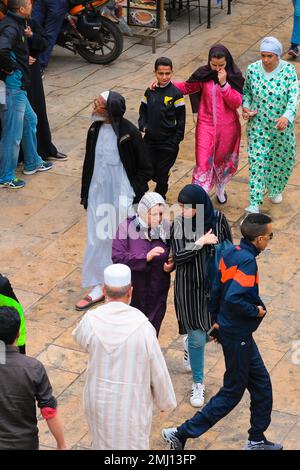 Fez, Marokko – auf dem Rundgang durch die Medina von Fez el Bali wurden muslimische Frauen und Männer in islamischer Kleidung behandelt. Geschäftiger Souk (Markt) mit Leuten. Stadtbild Fez, Hintergrund. Stockfoto