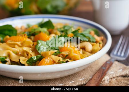 Veganer Teriyaki Pasta Salat mit Cashews, Mandarinen Orangen und Spinat Stockfoto