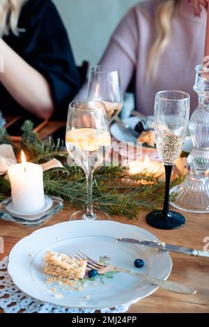 Zwei Gläser Alkohol auf dem Silvestertisch. Ein Glas Champagner und ein Cocktail mit Zitrone in einem Glas, vor dem Hintergrund der Menschen Stockfoto