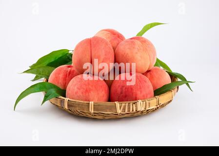 Frische rote Pfirsiche in einem Bambuskorb. Stockfoto