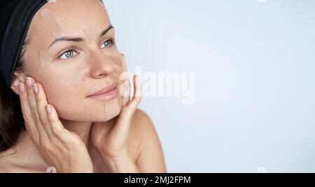 Schönheitskonzept Gesichtspflege Frau, die kinesiologische Gesichtsbänder auf ihr Gesicht aufklebt, Anti-Falten-Therapie. Stockfoto