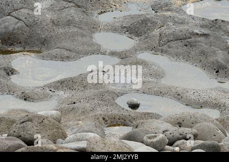 Wasserquellen im vulkanischen Felsen, die vom Meer erodiert wurden Stockfoto