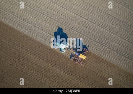 Draufsicht über Traktor mit pneumatischem Sämaschinen, landwirtschaftliche Maschine zum Aussaaten, Feldarbeiten im Frühjahr Stockfoto