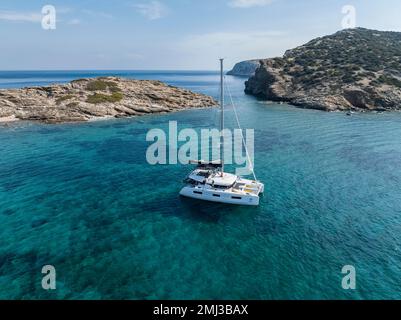 Luftaufnahme, Segelkatamaran auf dem türkisfarbenen Meer, kleine Kykladen, Griechenland Stockfoto