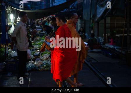 Mönche, die nachts durch Rom Hup Market spazieren - Thailand Stockfoto