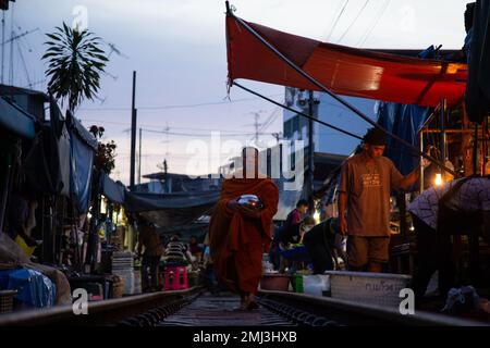 Mönch, der nachts durch Rom Hup Market geht - Thailand Stockfoto