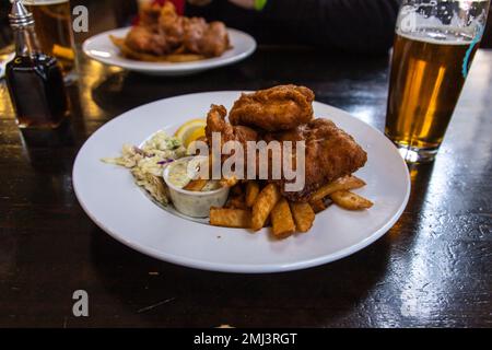 Traditioneller Fisch- und Chips-Teller, serviert im britischen Pub. Fish and Chips ist ein warmes Gericht, bestehend aus gebratenem Fisch, serviert mit Pommes Frites (französischer freitag Stockfoto