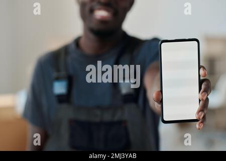 Nahaufnahme eines afroamerikanischen Mannes, der den leeren Bildschirm des Smartphones in der Kamera zeigt Stockfoto
