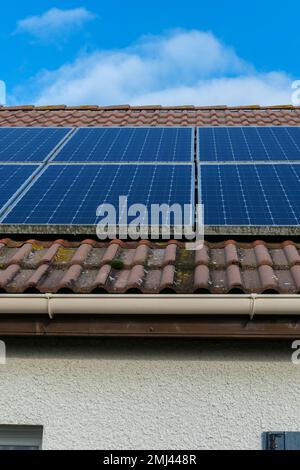 Auf dem Dach eines Hauses installierte Photovoltaikpaneele Sonnenkollektoren auf einem Dach. Stockfoto