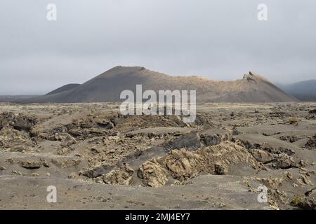 Ein alter Vulkankegel umgeben von Lava in Tinajo, Lanzarote Stockfoto