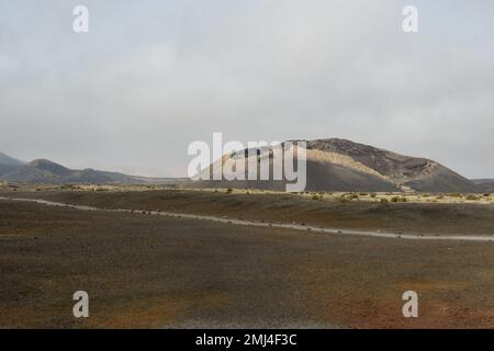 Ein alter Vulkankegel umgeben von Lava in Tinajo, Lanzarote Stockfoto