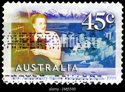 AUSTRALIEN - CA. 1999: Ein in AUSTRALIEN gedruckter Stempel zeigt die Englischklasse für Wanderarbeitnehmer in Cooma, Snowy Mountains Scheme, 50. Jubiläum, s. Stockfoto