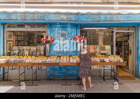 L'Isle-sur-la-Sorgue, Avignon, Vaucluse, Provence-Alpes-Cote d'Azur, Frankreich. 6. Juli 2022. Frau in einem kleinen Buchladen in L'Isle-sur-la-Sorgue. Stockfoto