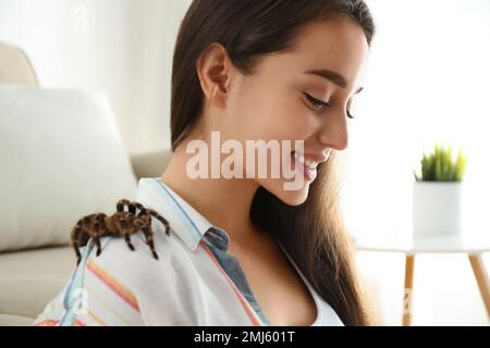 Junge Frau mit gestreifter Knietarantel auf der Schulter zu Hause, Nahaufnahme Stockfoto