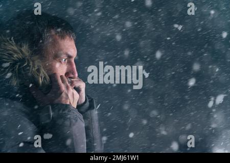 Mann in der Winterjacke Straße bei starkem Schneefall Stockfoto