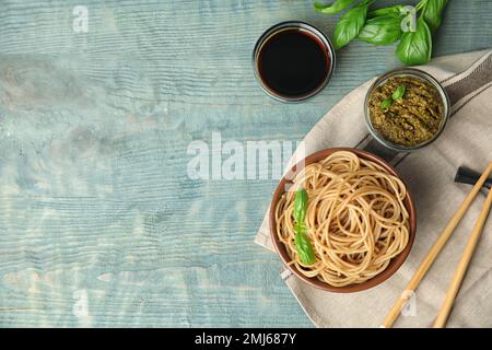 Leckere Buchweizen-Nudeln auf blauem Holztisch, flach liegend. Platz für Text Stockfoto